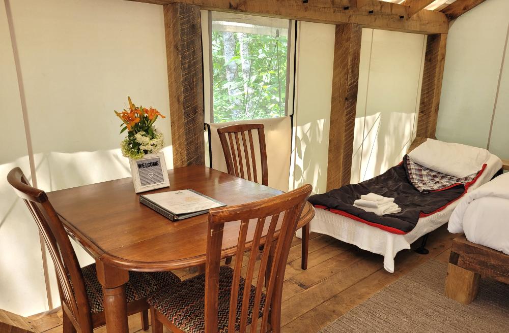 Interior of Birch Tent with dining table with cot add on for families