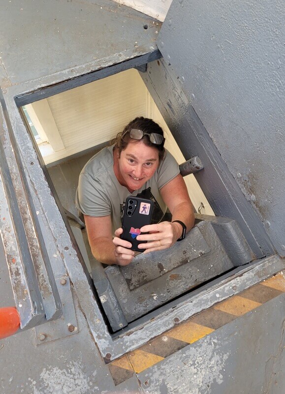 Climbing through the hatch inside Walton Lighthouse overlooking the Minas Basin in Nova Scotia